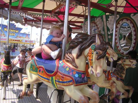 Sarah rides the carousel at the fair's carnival