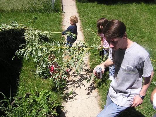 Noah and Andrea play with sticks in our new yard while david drinks root beer.