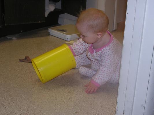 Sarah plays with toys on the bathroom floor.