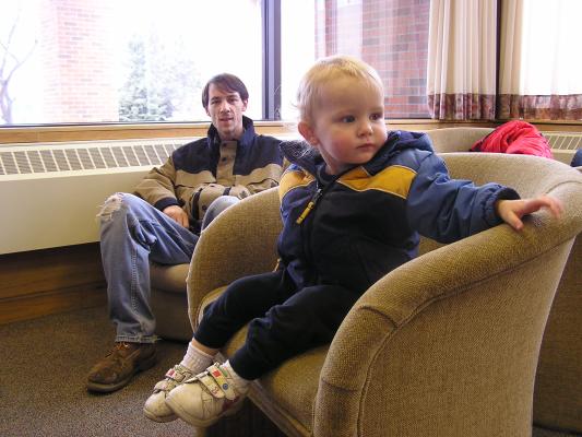 Noah sits in a chair in the student union.