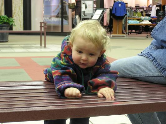Noah loves to play on the benches at the mall.