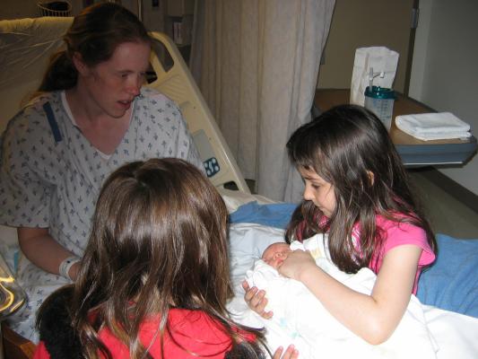 Malia holds Sarah on the hospital bed.