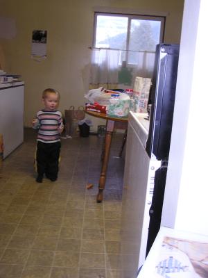 Noah plays in Great Grandpa's kitchen.