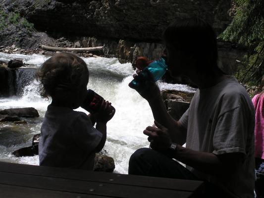 Noah and David enjoy some water at the water's edge.