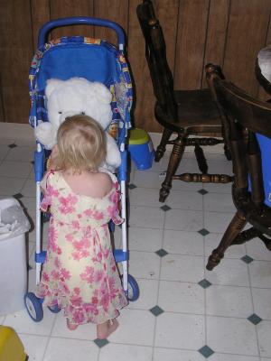 Sarah plays with a white bear in the stroller.