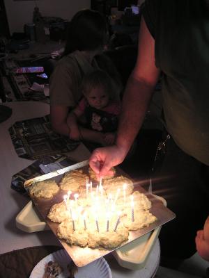 Benji lites Katie's birthday cake. Katie and Sarah watch
