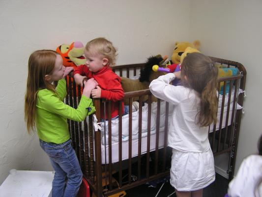 Allison and Jennah play with Noah in the nursery.