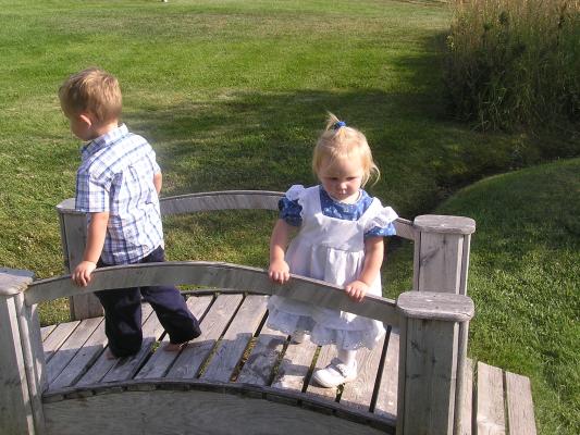 Noah and Sarah play on a bridge.