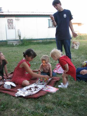 Malia, Noah and Sarah put on candles. David watches