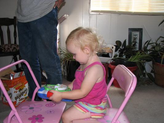 Sarah plays with the Phonics Radio on the pink chairs.