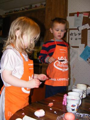 Sarah eats the egg. Noah waits for an egg to be dyed.