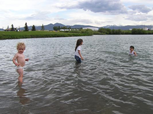 Malia, Andrea, and Noah play in the lake.