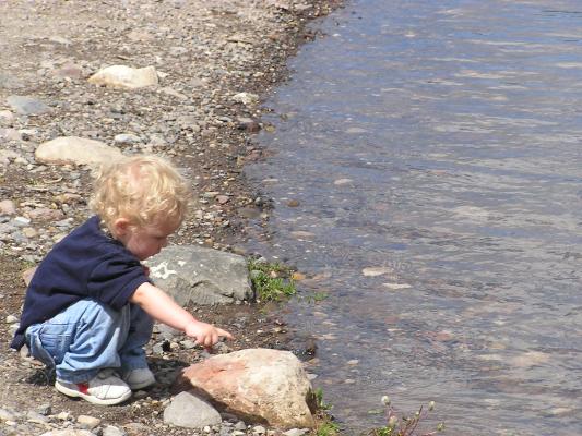 Noah likes to throw rocks into the water.