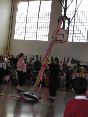Someone gathers up the May pole.