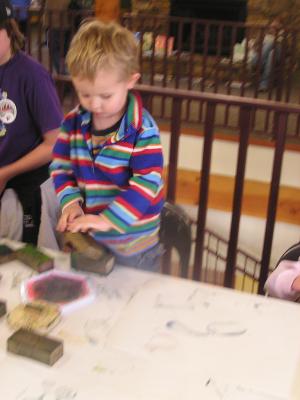 Noah plays with a bird stamp