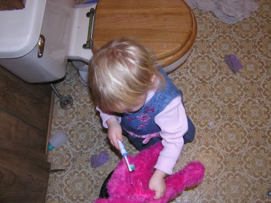 Sarah brushes the bear's teeth