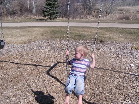 Noah plays on the swings.