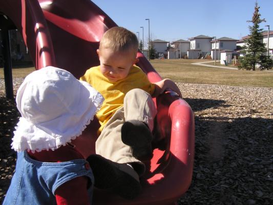 Sarah is ready to catch Noah on the slide.