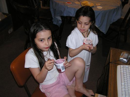 Malia and Andrea eat some yogurt.