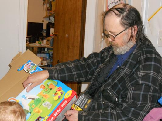 Robert (Grandpa) looks at the box. 