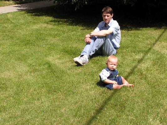 David and noah sitting on the grass.