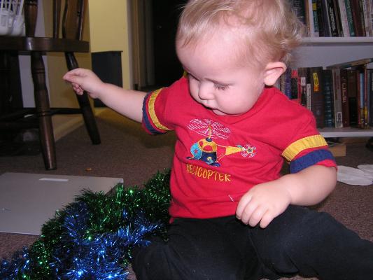 Noah plays with green and blue tinsel.
