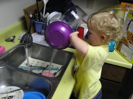 Noah washing a purple bowl.