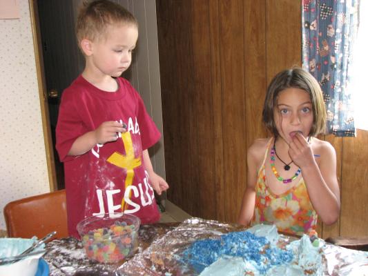 Noah and Andrea decorate Noah's airplane cake.