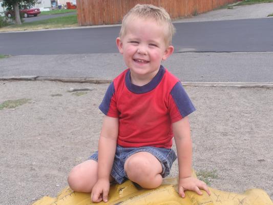 Noah on a tire at the park.
