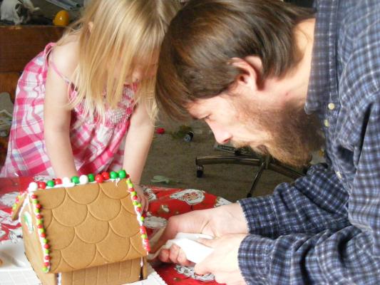 Sarah and David work on a gingerbread house