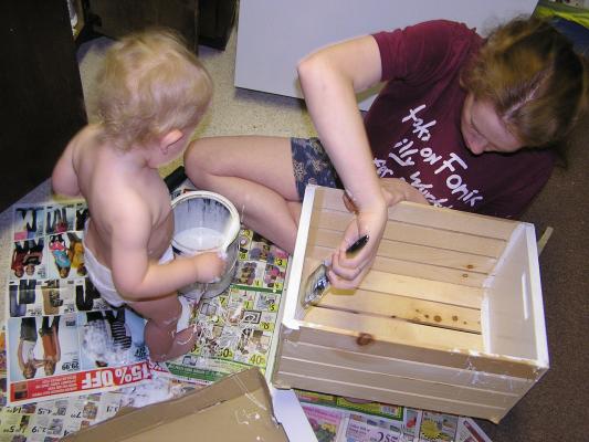 Noah and Katie are painting a wooden box.