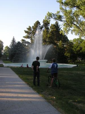 David and Joe talk while Sarah and Noah play in the Fountain