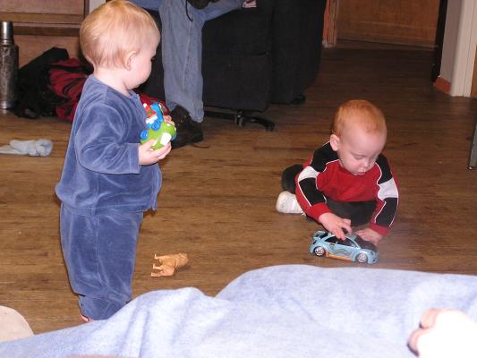 Sarah watches Steven play cars.