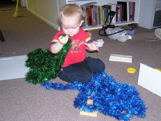 Noah plays with green and blue tinsel.