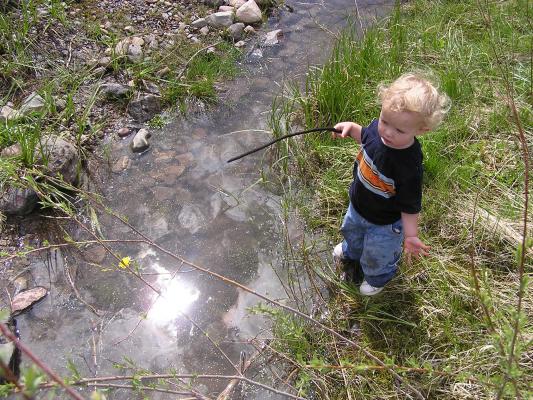 Noah with his stick by the water.