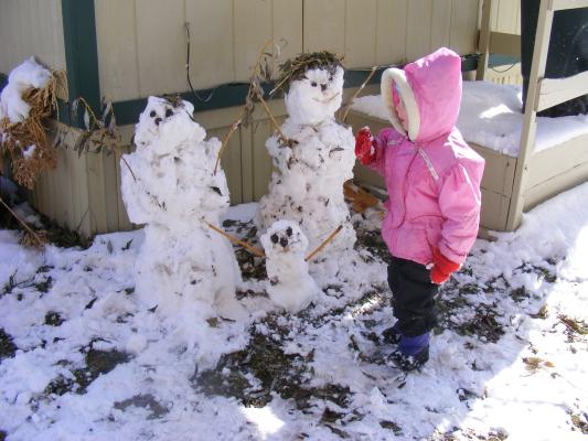 Sarah with a boy, girl and baby snowman.