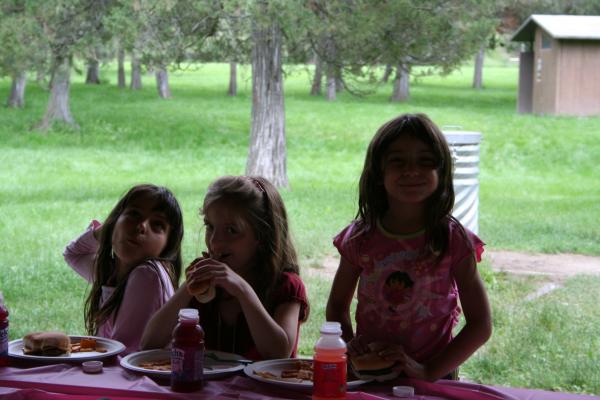 Malia, Nicole and Andrea eat some hamburgers and hotdogs.