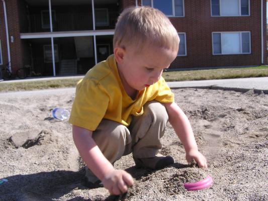 Noah plays in the sand.