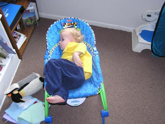 Noah sits in the baby chair.