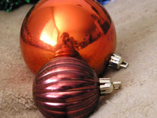 The reflection of me holding Sarah and tkaing a picture of Christma balls.