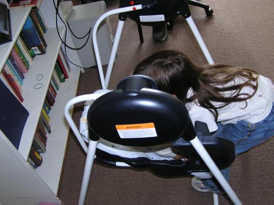 Andrea puts Sarah in her swing.