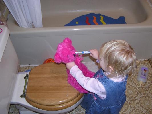 Sarah brushes the bear's teeth