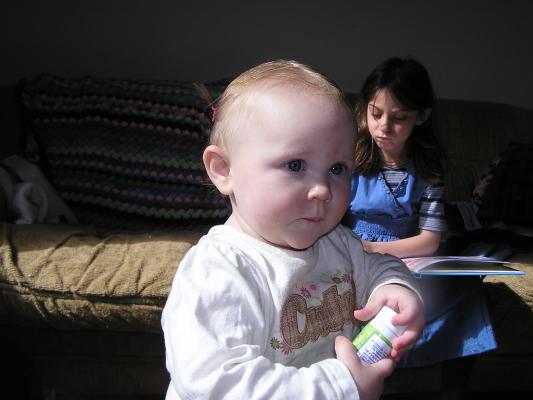 Sarah is playing with toothpaste. Andrea looks at a book.