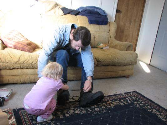 Sarah help daddy tie his shoes.