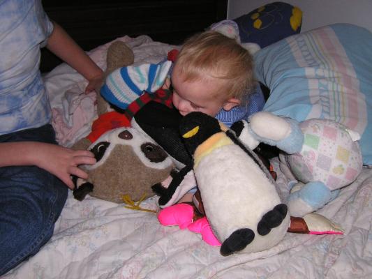 Noah is burried in stuffed toys.