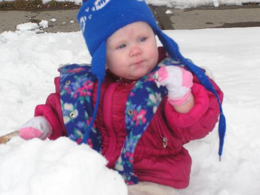 Sarah eats some snow with her sock-covered hands.