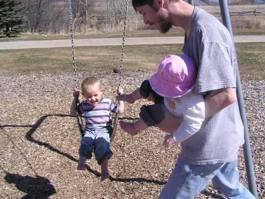 Noah plays on the swings.
Sarah gets Noah's toes with her toes.