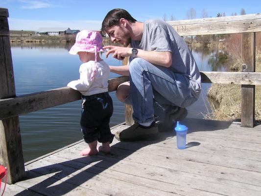 Sarah throws rocks off the dock.
