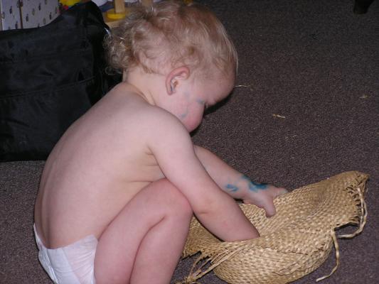 Noah plays with an old straw hat.