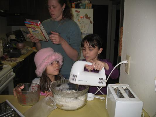 Malia and Andrea help bake the cake.